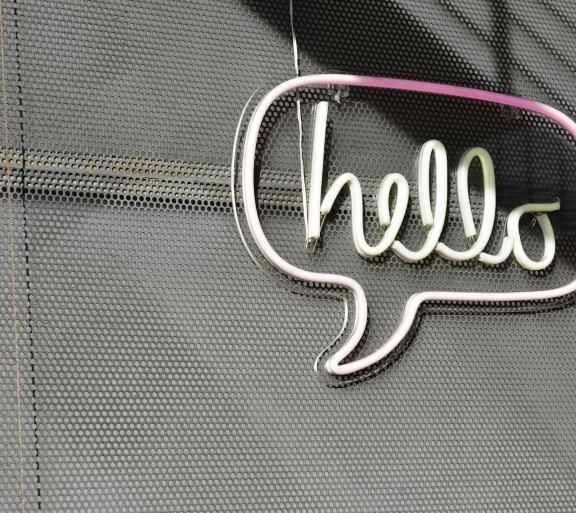 "hello" neon sign on concrete wall