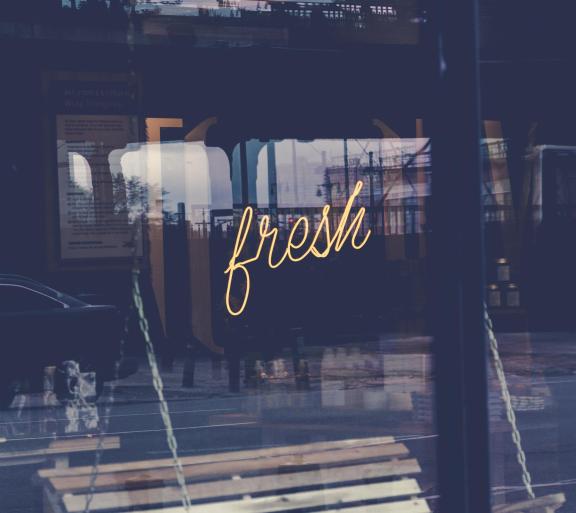 neon sign in window that reads "fresh"