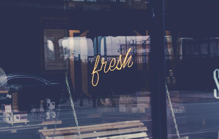 neon sign in window that reads "fresh"