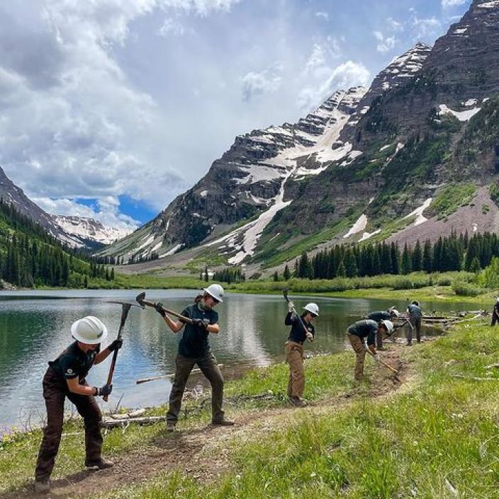 people working on a trail in the mountains