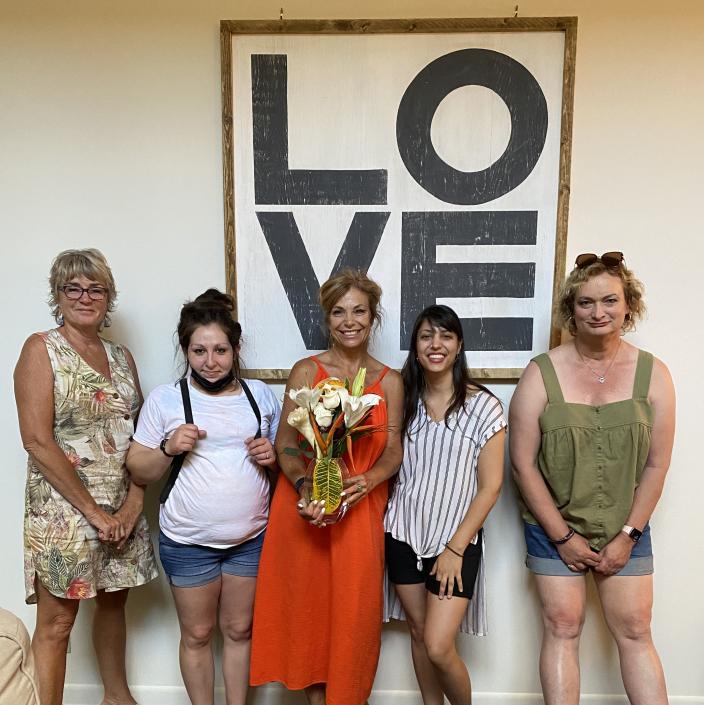 women in front of a sign