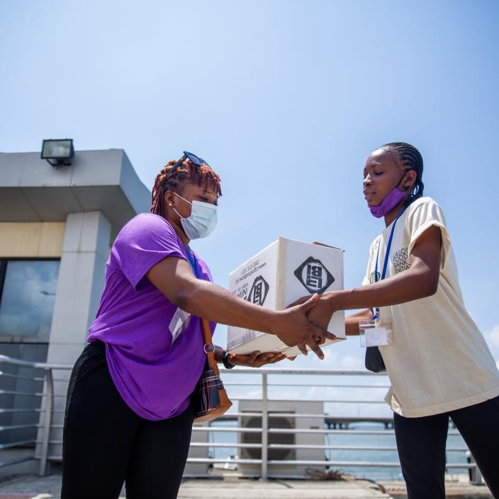 women carrying a box