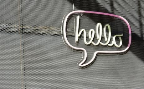 "hello" neon sign on concrete wall