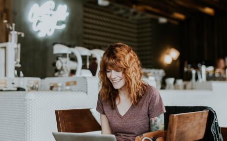 red haired woman typing on laptop