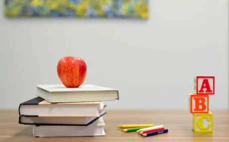 apple on stack of books on a desk