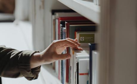 person touching bookshelf